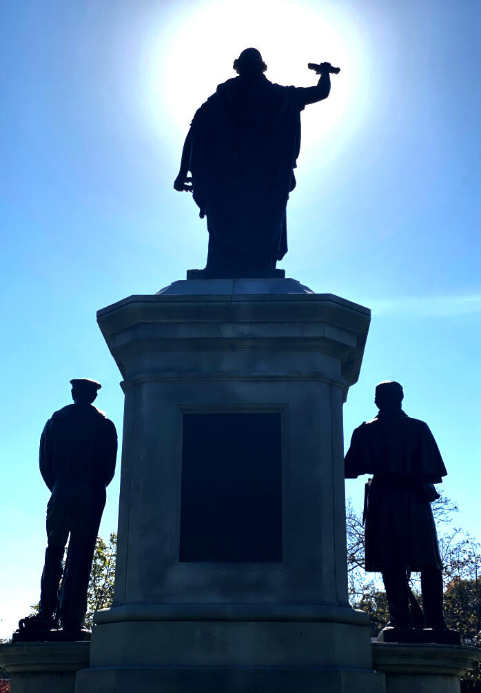 Backlit Statues Three statues of people being backlit by the sun.